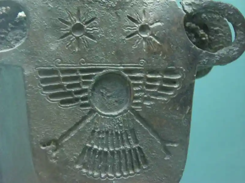Solar symbols and winged disc on a bronze lion feet figurine
